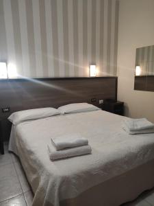 米兰索尔斯酒店的一间卧室配有一张床,上面有两条毛巾