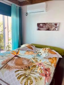 圣若瑟la villa TIKALIKATA的一间卧室配有一张带彩色毯子的床
