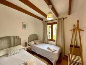 波连斯萨Encant的一间卧室设有两张床和窗户。