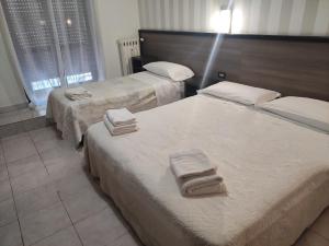 米兰索尔斯酒店的两张位于酒店客房的床,配有毛巾