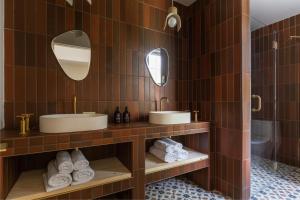 普莱西德湖Eastwind Hotel Lake Placid的浴室设有2个水槽、2面镜子和毛巾