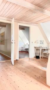 SkovbyBakkehuset Countryhouse的一间空房间,设有木制天花板和一张桌子