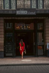 墨西哥城Historico Central Hotel的穿着红色衣服的女人在商店前走
