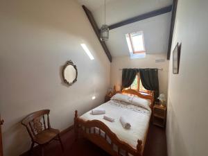 Llangwm-isaf4 beautiful stone built barns sleeping 17 people的一间卧室配有一张带镜子和椅子的床