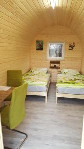 诺尔德霍尔茨Glamping Pod im Wald mit Einzelbetten的一间设有两张床和一张桌子及椅子的房间