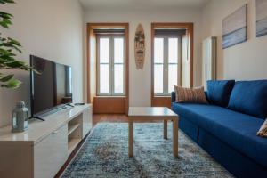 马托西纽什Porto Metro-At-Home Apartment的客厅配有蓝色的沙发和电视
