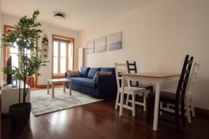 马托西纽什Porto Metro-At-Home Apartment的客厅配有桌子和蓝色沙发