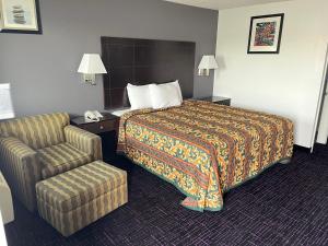 圣安东尼奥Broadway Inn Motel的配有一张床和一把椅子的酒店客房