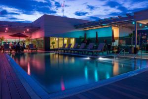 特古西加尔巴特古西加尔巴凯悦嘉轩酒店的一座带椅子的夜间游泳池以及一座建筑