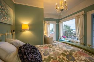 阿斯托里亚Clementine's Guest House & Vacation Rentals的一间卧室配有一张床、一个吊灯和一扇窗户