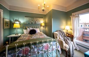 阿斯托里亚Clementine's Guest House & Vacation Rentals的一间卧室设有绿色的墙壁、一张床和一个吊灯。