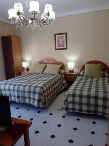 Catí卡萨安琪利塔旅馆的一间卧室配有两张床和吊灯。