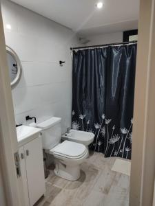 皮纳马尔Duplex Pinamar norte frente al bosque的浴室设有卫生间和黑色淋浴帘
