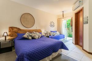 弗洛里亚诺波利斯Pousada Penareia Floripa的一间卧室配有一张带蓝色棉被的床