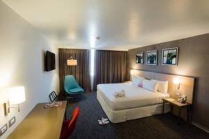 塔克纳BTH Rebel Tacna的配有一张床和一张书桌的酒店客房