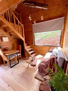 丰沙尔Mountain Eco Shelter 5的小屋内配有沙发和楼梯的房间
