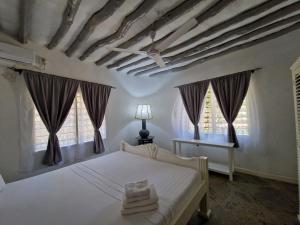 瓦塔穆Waridi House的卧室配有白色的床和2扇窗户。