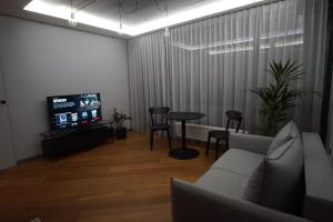 维尔纽斯Cozy apartment with underground parking的带沙发、桌子和电视的客厅