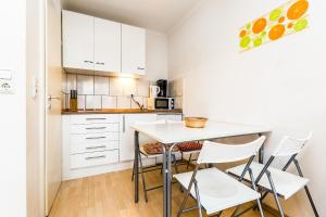 科隆Work and Stay Koeln Ostheim的厨房配有白色橱柜和桌椅