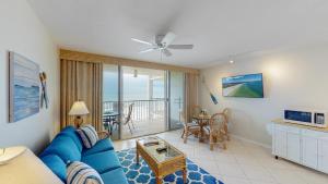 马可岛Beachfront 1 Bed w/ On Site Tiki Bar/Restaurant!的客厅配有蓝色的沙发和桌子