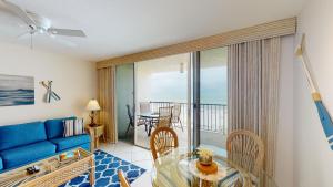 马可岛Beachfront 1 Bed w/ On Site Tiki Bar/Restaurant!的客厅配有蓝色的沙发和玻璃桌