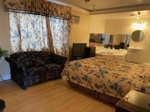 蒙特利尔皮埃尔汽车旅馆的一间卧室配有一张床、一张沙发和一面镜子