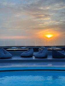 易莫洛林Abrazo Villas的一个带蓝色枕头的游泳池,享有日落美景