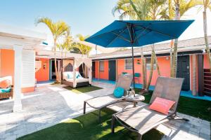 圣徒皮特海滩Cabanas of Treasure Island的庭院配有两把椅子和蓝伞