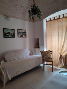 阿尔贝罗贝洛拉奎拉住宿加早餐旅馆的卧室配有床、椅子和窗户。