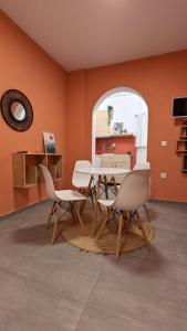 Áno MeriáUnder The Palm Tree Studios的一间拥有橙色墙壁和桌椅的用餐室