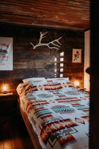 BusserollesLa ferme du pont de Maumy, cabane au bord de l'étang et bain nordique的卧室配有一张带鹿头的墙壁床。