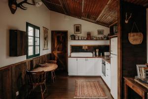 BusserollesLa ferme du pont de Maumy, cabane au bord de l'étang et bain nordique的厨房配有白色橱柜和桌子