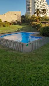 维纳德马Hermosa Casa Reñaca con Vista al Mar的公园内的游泳池,带围栏
