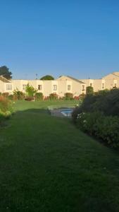 维纳德马Hermosa Casa Reñaca con Vista al Mar的庭院,带绿色草坪,后面有房子