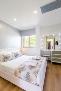 干尼亚Gk Halepa Luxury apartment的白色卧室配有一张大床和一张书桌