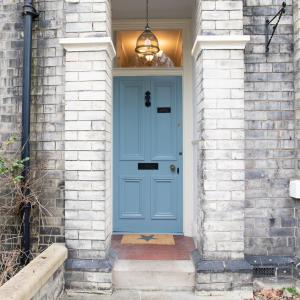 约克35 Grosvenor Terrace - 5 min walk from York City Centre的砖屋上的一扇蓝色门,灯具
