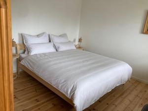 比绍夫斯维森Watzmannkar的一张带白色床单和枕头的床