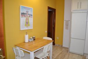 加的斯Apartamento Posidonia Free Parking的厨房配有桌椅和黄色墙壁