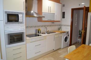 加的斯Apartamento Posidonia Free Parking的厨房配有白色橱柜、水槽和微波炉
