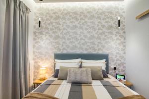 雅典Luxurious apt near Ampelokipoi Metro station的一间卧室配有一张大床和蓝色床头板