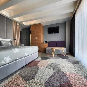 萨拉热窝Hotel City View Deluxe的一间卧室配有一张床和一台平面电视