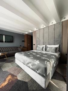 萨拉热窝Hotel City View Deluxe的一间卧室配有一张大床和一张沙发