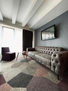 萨拉热窝Hotel City View Deluxe的客厅配有沙发和墙上的电视