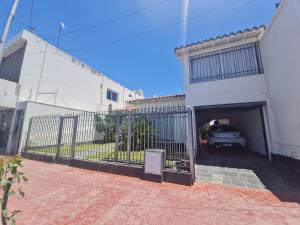 圣马丁MENDOZA TURiSTA - CASA EN SAN MARTÍN, MENDOZA "ANTONIO's HOUSE"的一座白色的建筑,里面装有汽车车库