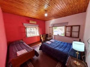 乌尼翁镇Mis Marias的一间带两张床和红色墙壁的卧室