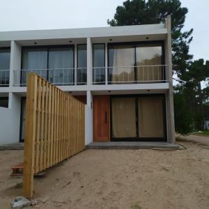 皮纳马尔Duplex Pinamar norte frente al bosque的前面有木门的房子