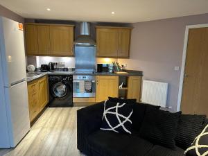 沃灵顿MODERN 2 BEDROOM 2 BATHROOM APARTMENT SLEEPS 4 IN WARRINGTON FOR WORK AND LEISURE WITH PRIVATE PARKING BY AMAZING SPACES RELOCATIONS Ltd的带沙发的客厅和厨房