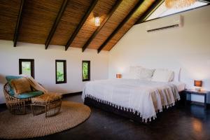 圣塔特蕾莎海滩Lua Villas的一间卧室配有一张大床和一把椅子