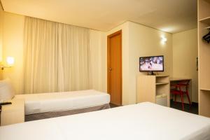 贝伦ibis Styles Belem Batista Campos的酒店客房设有两张床和一台平面电视。