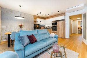 伏尔塔瓦河畔利普诺Apartament A121 Molo Lipno s infrasaunou - Residence Koubek的一间带蓝色沙发的客厅和一间厨房